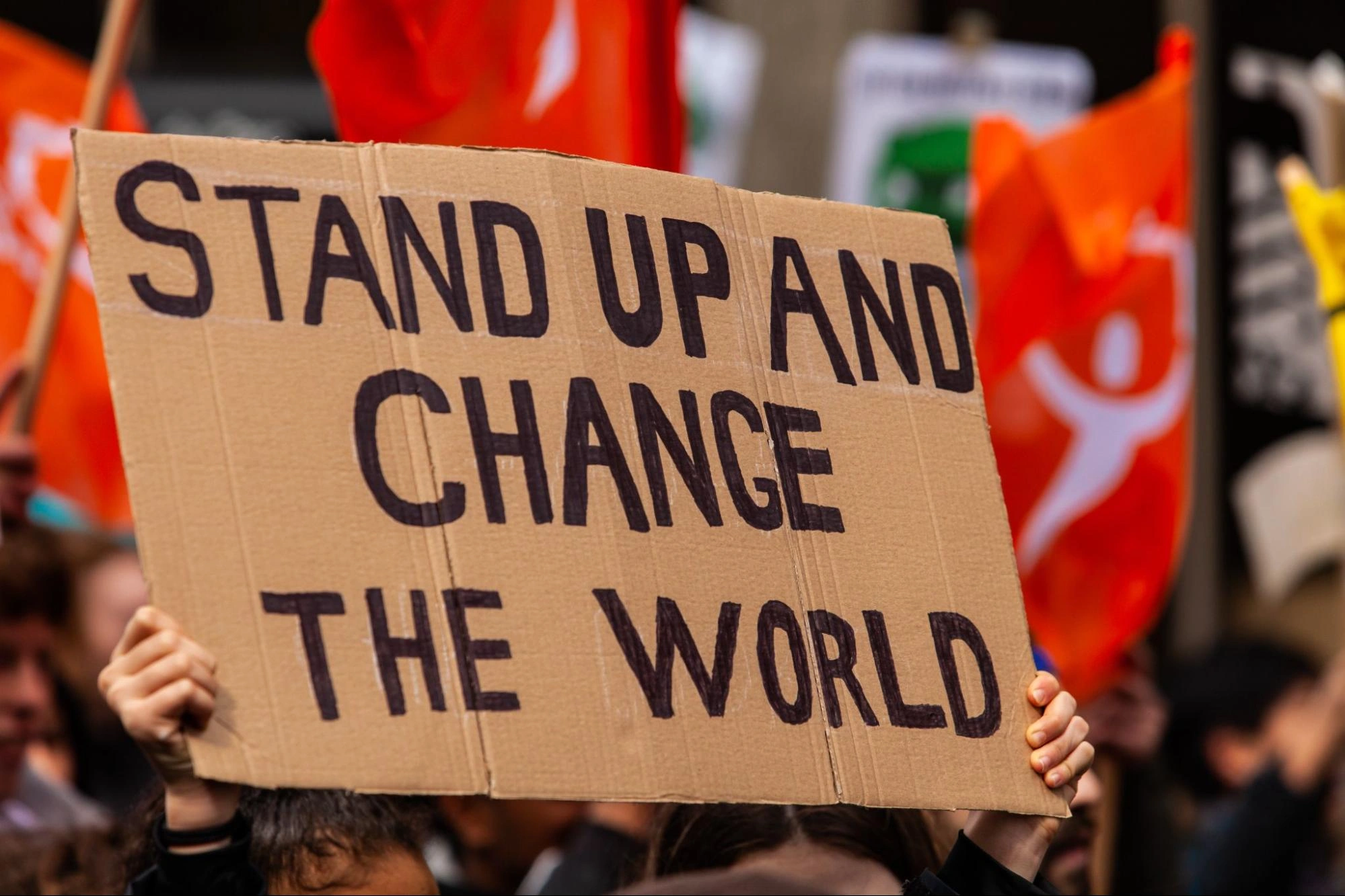 protest sign saying stand up and change the world